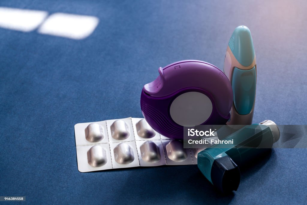 Set of asthma inhaler, accuhaler and anti-allergy pills for treatment asthma. Asthma controller, reliever equipment on dark blue background. Bronchodilator and steroids drug for severe asthma. Asthmatic Stock Photo