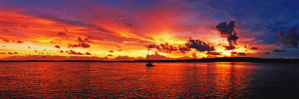 istock Golden colored coastal panoramic sunrise seascape cloudscape. 946389040