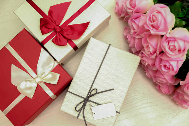 istock Present gift box and ribbon on white wood table 946403728