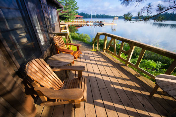 muskoka stühlen sitzen auf einer holzveranda - landhaus stock-fotos und bilder