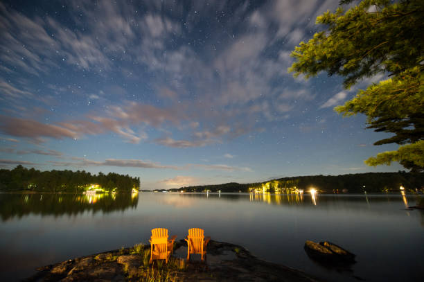 istock Adirondack chairs on a rock formation under a sky full of stars 946424112