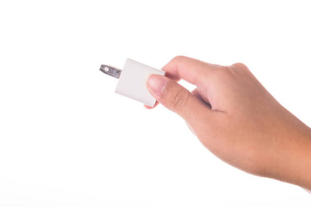 istock Hand holding electric plug isolated on white background 946426594