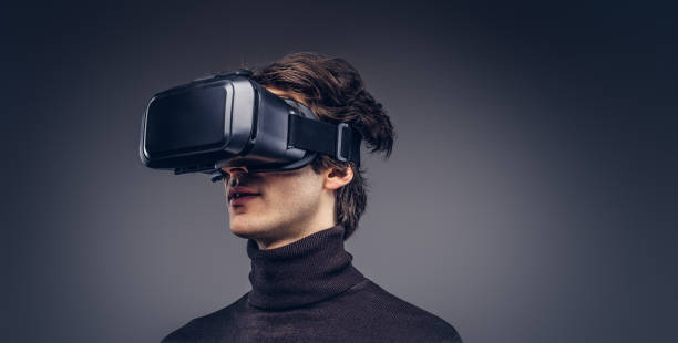 istock Portrait of a man wearing virtual reality device isolated on a d 946436856