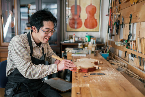 istock Craftsman carving a violin 946441646