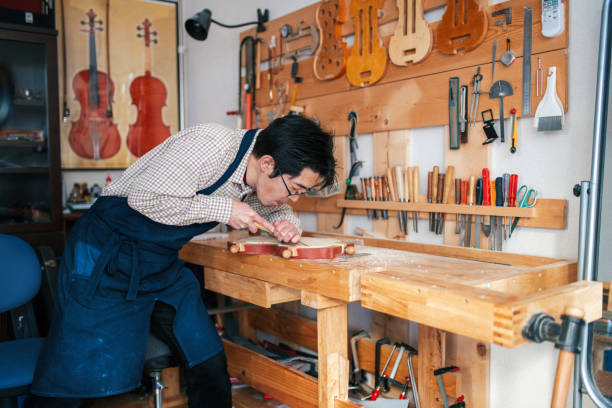 istock Craftsman carving a violin 946441648