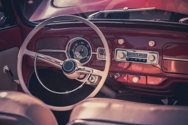 Photo of Close-up, detailed photo of the interior, dashboard, steering wheel and speedometer of a classic oldtimer luxury sports car.