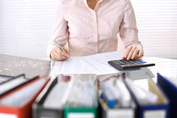 istock Female bookkeeper or financial inspector  making report, calculating or checking balance. Internal Revenue Service checking financial document. Audit concept in busines 946450870