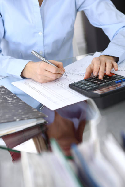 istock Female bookkeeper or financial inspector  making report, calculating or checking balance. Internal Revenue Service checking financial document. Audit concept in busines 946450880