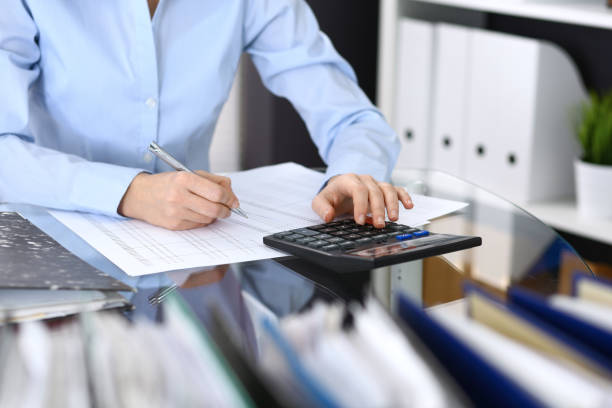 istock Female bookkeeper or financial inspector  making report, calculating or checking balance. Internal Revenue Service checking financial document. Audit concept in busines 946450906