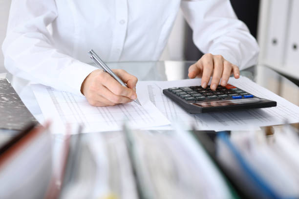 istock Female bookkeeper or financial inspector  making report, calculating or checking balance. Internal Revenue Service checking financial document. Audit concept in busines 946450960
