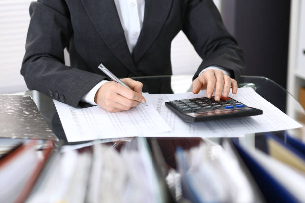 istock Female bookkeeper or financial inspector  making report, calculating or checking balance. Internal Revenue Service checking financial document. Audit concept in busines 946451002