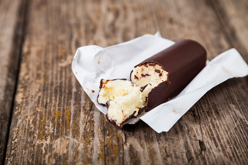 Sweet cottage cheese in chocolate on a wooden table. Healthy dairy products.