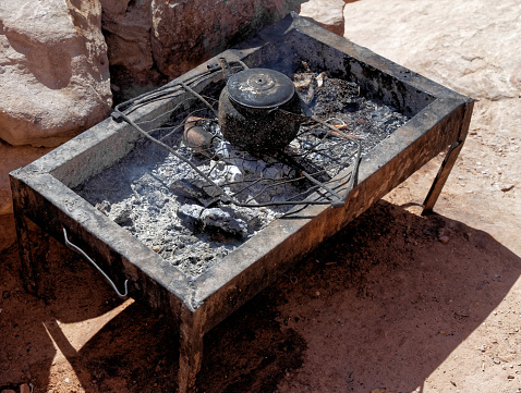 Bedouin stove with a kettle boiling water by the stairs to the Al-Deir Monastery in Petra, Jordan