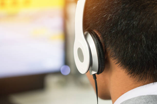 istock Education e-learning foreign languages Concept : Student Young man wearing Headphones listening English songs music and searching for learning abroad in classroon of university 946458338
