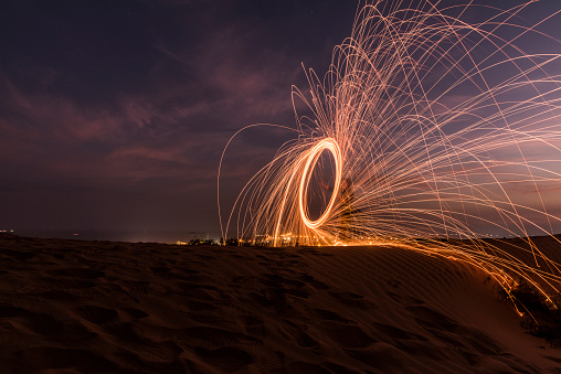 Fire spin wheel abstract effect at night in dessert