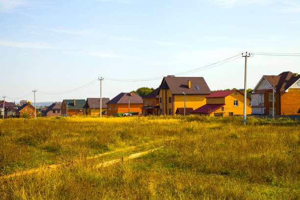 Cottage village near the meadow in the autumn day. Luxury country real estate.