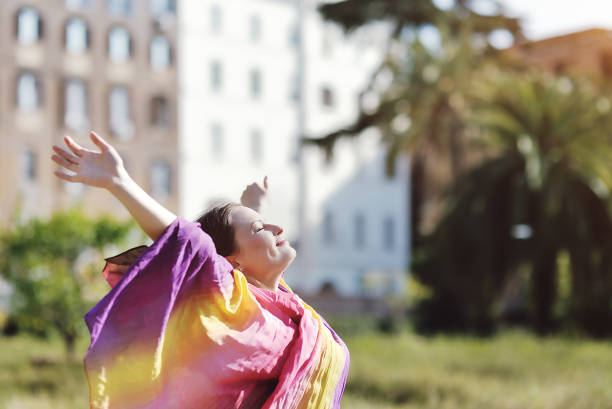 istock woman relaxing with open arms and face to sun 946468942