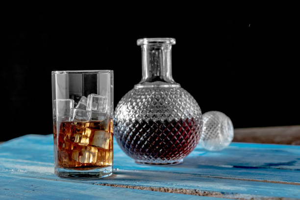 istock Glass of Ice cube on blue wooden table background. 946469542