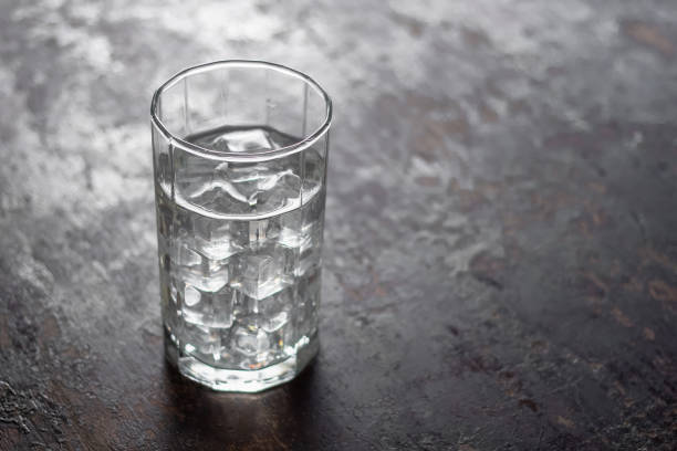 istock Glass of water with ice on black background 946469546