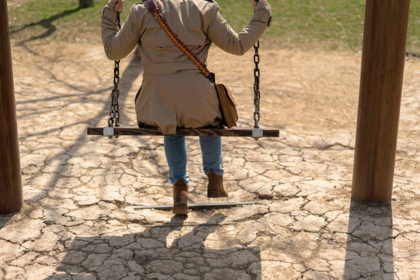 girl sitting on swing in public park