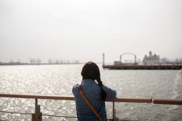 istock girl enjoying harbor seascape 946484022