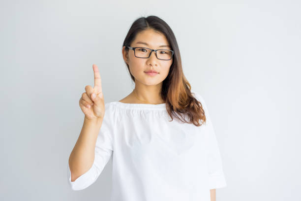 istock Confident well-educated young woman showing index finger 946490728