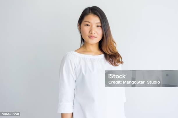 Serious Beautiful Young Chinese Woman In White Blouse Stock Photo - Download Image Now