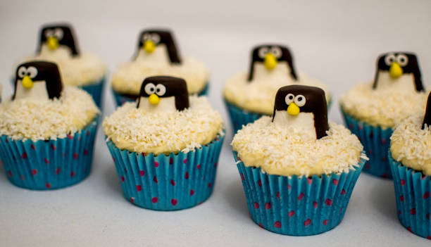 Coconut cupcakes with chocolate marshmallow penguins. stock photo