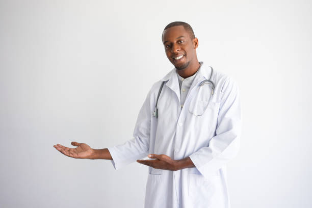 istock Happy doctor pointing at empty space and presenting product 946502480