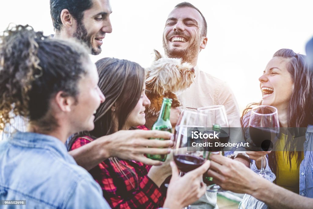 Amigos felizes tomando selfie durante o jantar de festa no quintal de casa - grupo de jovens se divertindo com tecnologias de tendências - focar o homem certo - juventude, amizade, verão, conceito de estilo de vida da juventude - Foto de stock de Vinho royalty-free