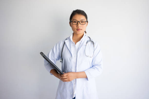 istock Serious young Asian female doctor holding folder 946502646