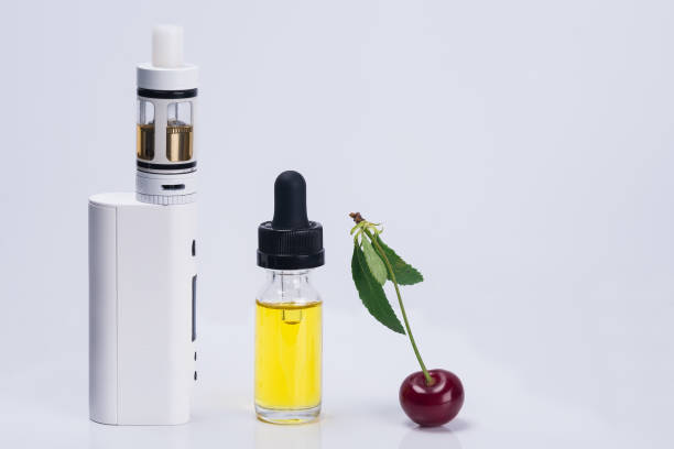 istock electronic cigarette and liquid for its refilling with a cherry on a white background 946503076