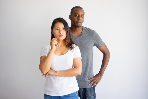 Portrait of two interracial male and female students. Young African American man and Asian woman advertising student exchange program. Mixed culture and exchange program concept