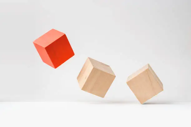 Photo of abstract geometric real wooden cube with surreal layout on white floor background