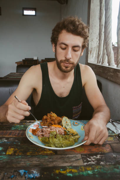 istock Man eats Balinese food  at restaurant 946512890