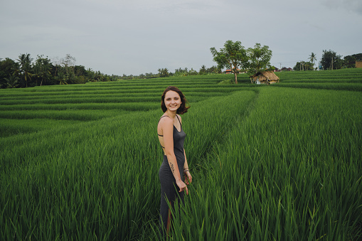 Young Caucasian woman walking on rice field in Bali, Indonesia