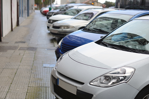 image of cars parked in a row on a city street