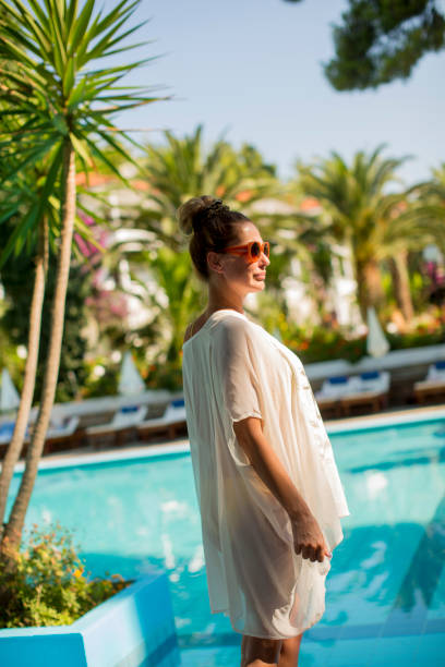 istock Young woman standing next to the swimming pool 946521152