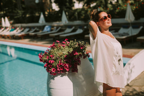 istock Young woman standing next to the pool 946521194