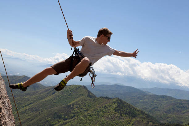 adolescente em pleno ar salto da face da rocha, piemonte, itália - on top of reaching mountain arms outstretched - fotografias e filmes do acervo