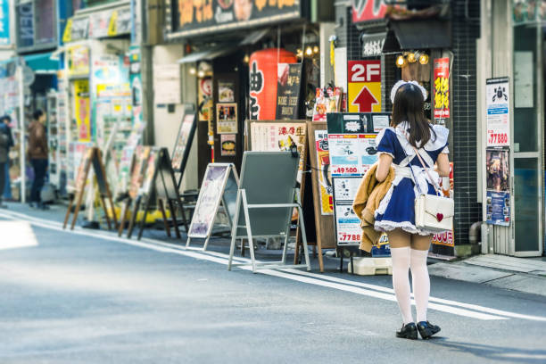 可愛いメイドさんが青い空と晴れた日の下で東京都の秋葉原の広告を送信します。 - 秋葉原 ストックフォトと画像