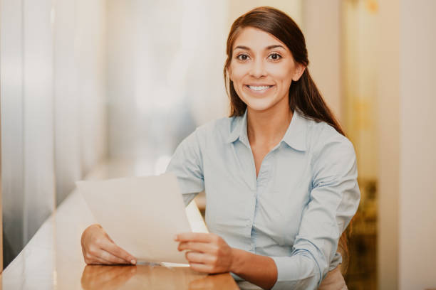istock Smiling Pretty Woman Holding Document in Cafe 946533354