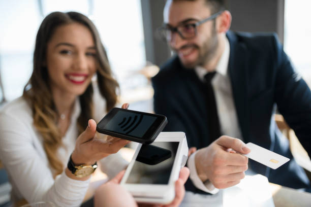 Business advisors making mobile payment at restaurant