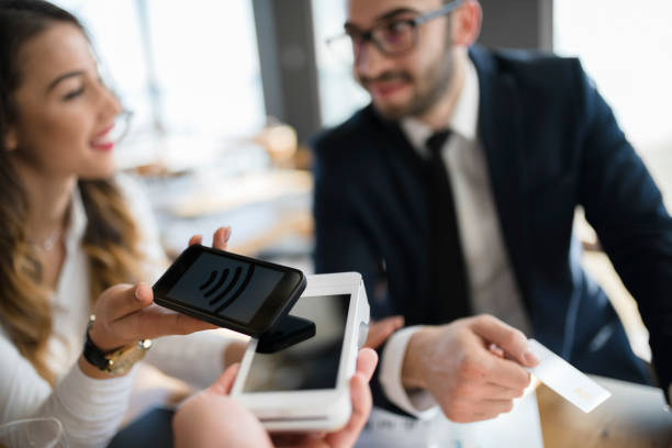 istock Business executives completing transaction with mobile phone 946553296