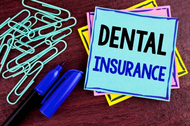 istock Handwriting text Dental Insurance. Concept meaning Dentist healthcare provision coverage plans claims benefit written on Sticky Note Paper on wooden background Marker and Paper Clips next to it. 946554272