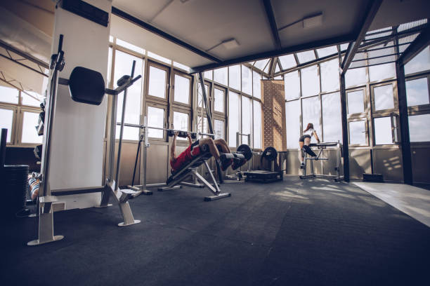 istock Young man exercise with dumbbell in gym 946559754