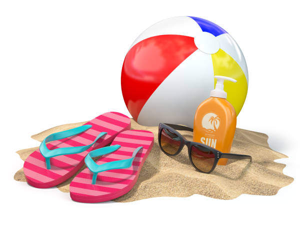 istock Beach accessories for relaxing. Sunscreen bottle, flip flops, sunglasses and ball onthe sand. 946566596