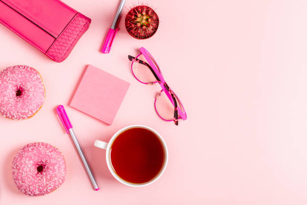 istock Cup of tea with donuts on a pink pastel background 946566934