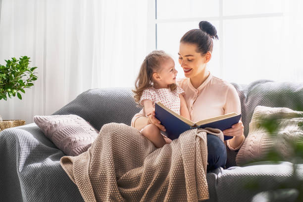 istock Mom and child reading a book 946566996