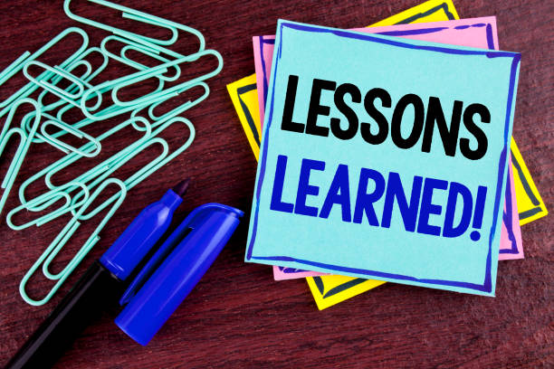 istock Handwriting text Lessons Learned Motivational Call. Concept meaning Academic student development optimization written on Sticky Note Paper on wooden background Marker and Paper Clips next to it. 946567638
